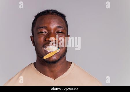 africa man toothbrush in gray background isolate Stock Photo