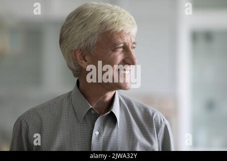 Happy dreamy handsome old retired business man looking away Stock Photo