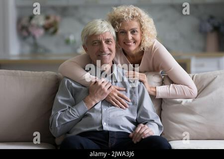 Happy pretty wife hugging senior husband from behind with love Stock Photo