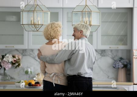 Happy mature couple enjoying cooking activities together, standing at table Stock Photo