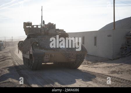 U.S. Soldiers assigned to 1st Battalion, 18th Infantry Regiment, 2nd Armored Brigade Combat Team, 1st Infantry Division maneuver a Bradley Fighting Vehicle through the town of Razish during Decisive Action Rotation 22-09 at the National Training Center, Fort Irwin, Calif., Aug 11th, 2022. (U.S. Army photo by Cpl. Dominic Acuna, Operations Group, National Training Center) Stock Photo