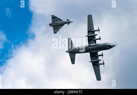 An Austrian Air Force Eurofighter Typhoon aircraft flies alongside an Austrian Air Force C-130K Hercules over the Airpower 22 air show in Zeltweg, Austria, Sept. 2, 2022. This multi-national event showcased the capabilities of over 20 nations to over 275,000 spectators from around the world, and provided an opportunity for the U.S. Air Force to continue to strengthen international partnerships. (U.S. Air Force photo by Staff Sgt. Kevin Long) Stock Photo