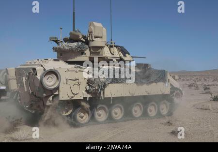 U.S. Soldiers assigned to 5th Squadron, 4th Cavalry Regiment, 2nd Armored Brigade Combat Team, 1st Infantry Division maneuver an M2 Bradley over terrain during Decisive Action Rotation 22-09 at the National Training Center, Fort Irwin, Calif., Aug. 14th, 2022 (U.S. Army photo by Pfc. Jeffrey Garland, Operations Group, National Training Center) Stock Photo