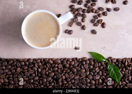 Top view with place for text roasted coffee beans border and cup of coffee on a light brown background. Stock Photo
