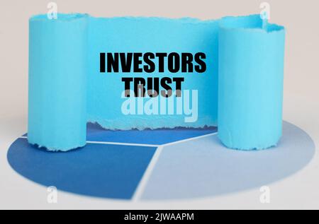 On the blue diagram is a twisted paper sign with the inscription - Investors trust Stock Photo