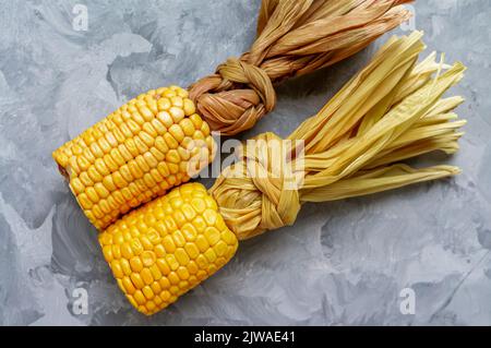 Grilled corn on the cob over white wooden surface, top view. Summer food. From above, overhead, flat lay. Close-up. Stock Photo