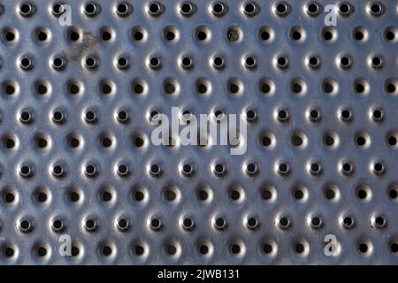 view of a steel plate with small round holes punched out Stock Photo