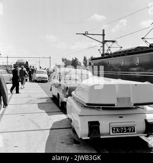 Image of a row of cars for entering a car sleeping train on the N.S. station Amsterdam-Amstel in Amsterdam. On the right the electric locomotive no. 1307 (series 1300) of the N.S. Stock Photo