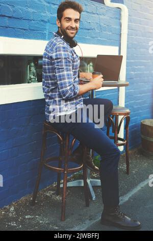 Coffee and connectivity. a handsome young man sitting at a sidewalk cafe. Stock Photo