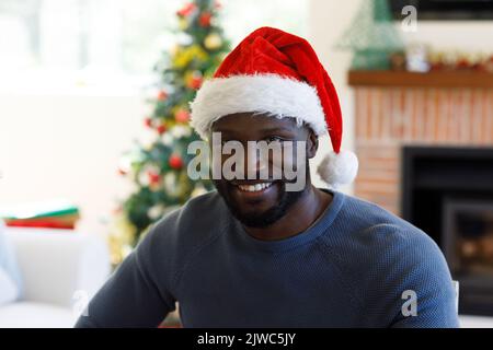 Portrait of african american man wearing santa hat Stock Photo