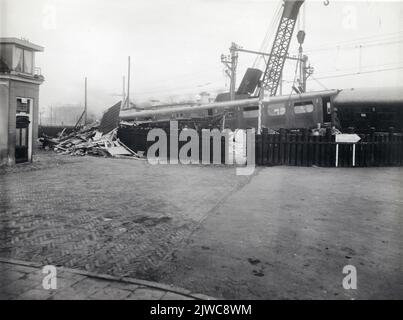 Image of the Electric train set no. 605 (Mat. 1936) of the N.S. After the collision with a freight train on the railway crossing in the Houtsepad in Utrecht. On the left the remains of the Wachterswoning 2 destroyed by the derailed train couple at the level crossing (Zijke Lamstraat). Stock Photo