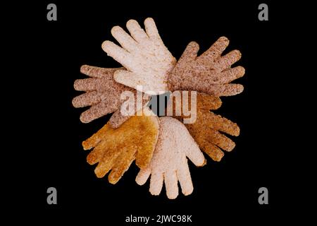Multicultural hands together in a circle made from toasted bread on a black background Stock Photo