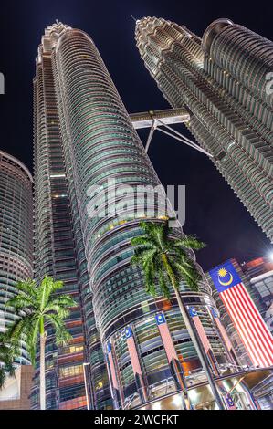 Portrait, close-up image of the Petronas Twin Towers with the Malaysian Flag in the foreground, Kuala Lumpur, Malaysia Stock Photo