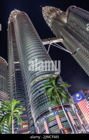 Portrait, close-up image of the Petronas Twin Towers with the Malaysian Flag in the foreground, Kuala Lumpur, Malaysia Stock Photo