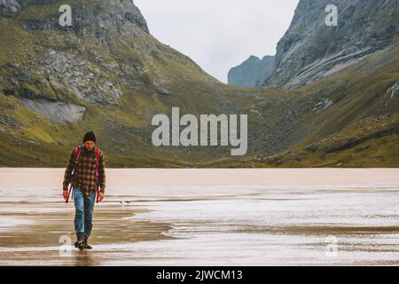 Man traveling in Norway hiking adventure trip outdoor active healthy lifestyle eco tourism Lofoten islands summer vacations Stock Photo