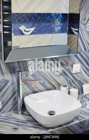 Modern washbasin with chrome faucet in stylish and bright bathroom of new house. Stock Photo