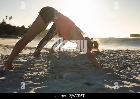 Beach Yoga Woman Doing Stretching Exercise Mind Body Spiritual Wellness  Stock Photo by ©PeopleImages.com 623857974