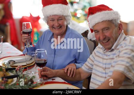 Senior caucasian couple sitting at table and drinking wine Stock Photo
