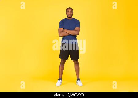 Determined African American Sportsman Crossing Hands On Yellow Studio Background Stock Photo