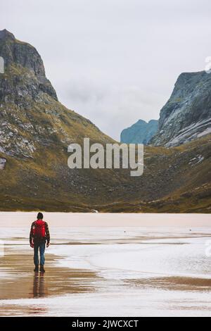 Man hiking solo in Norway travel adventure backpacking outdoor active healthy lifestyle sandy Horseid beach Lofoten islands summer vacations Stock Photo