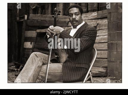 Posed portrait of Free Jazz violinist Billy Bang on the roof of an apartment house in the East Village, Manhattan, New York City. 1983 Stock Photo