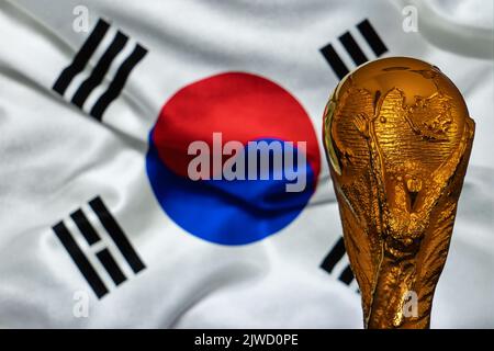 Doha, Qatar - September 4, 2022: FIFA World Cup trophy against the background of South Korea flag. Stock Photo