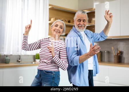 Home Fun. Joyful Senior Spouses Dancing Together In Kitchen Interior Stock Photo