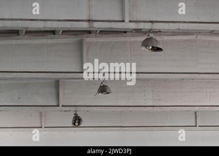Ceiling lights in abandoned industrial building close up, urban exploration Stock Photo