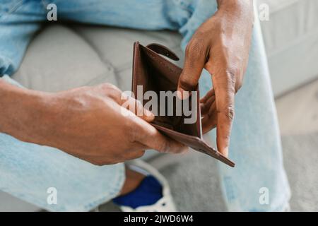 Financial crisis and bankruptcy concept. Unrecognizable black man showing empty wallet at camera Stock Photo