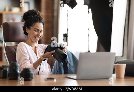 Beautiful creative woman photographer working, using laptop and camera Stock Photo