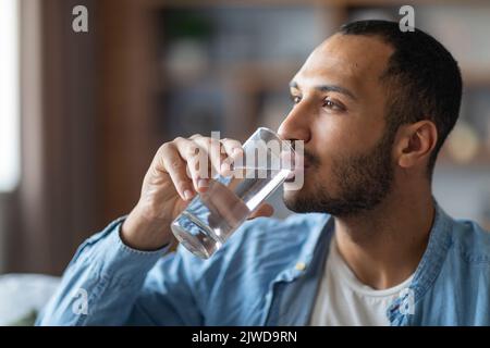 Portrait Of Handsome Young Black Man Drinking Water From Glass Stock Photo
