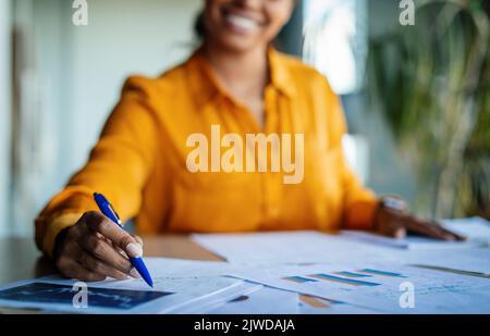 Female business analyst hands writing on papers, making notes and checking data, charts and graphs in office Stock Photo