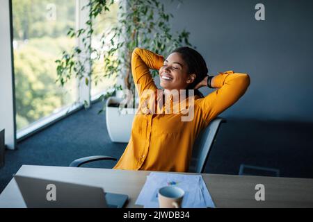 Taking break. Relaxed african american businesswoman resting on chair, leaning back at workplace in office Stock Photo