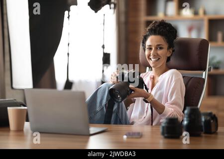 Happy millennial lady photographer working at office Stock Photo