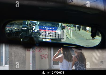 A police car in the rear view mirror in a traffic jam at a traffic light Stock Photo