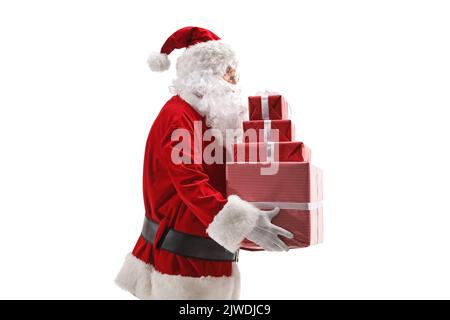 Santa Claus holding a pile of presents isolated on white background Stock Photo