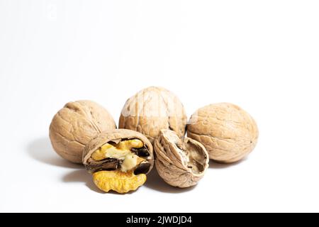 Walnuts isolated on a white background. Peeled and unpeeled walnuts. With clipping path. Nuts idea concept, healthy food with vitamins. No people. Stock Photo