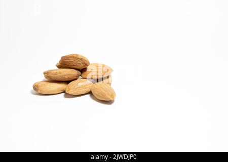 Group almonds isolated on white background. Pile of roasted almonds. Healthy food idea concept. Copy space, space for text. Empty area. No people. Stock Photo