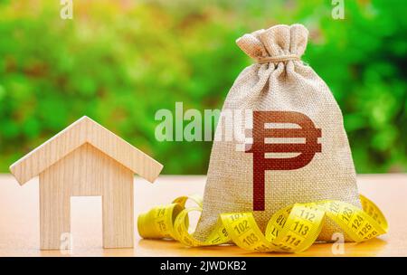 House and philippine peso money bag. Real estate appraisal. Property valuation. Building maintenance. Mortgage loan calculation. Budgeting. Cost of ho Stock Photo