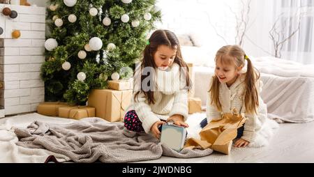 two little girls Sharing a Surprise on Christmas Morning Stock Photo