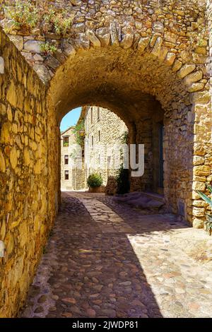 Stone arch in an alley with stone houses in the medieval town of Pals, Girona. Stock Photo
