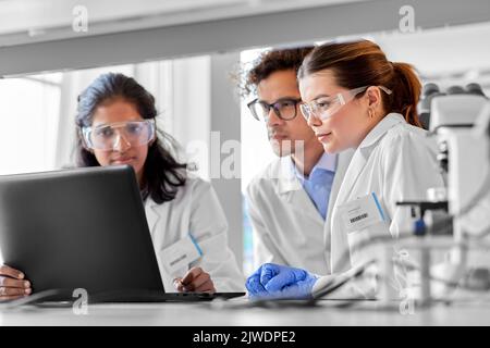 scientists with laptop working in laboratory Stock Photo