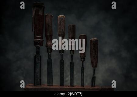 collection of vintage carving tools chisels on top of rustic workbench illustrating the concept of craftsmanship and creativity Stock Photo