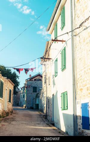 Old narrow street with stone buildings. Murter island, Croatia Stock Photo
