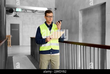 male supervisor with clipboard calling on phone Stock Photo