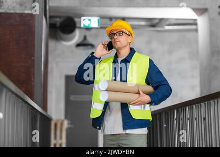 male architect with blueprint calling on phone Stock Photo