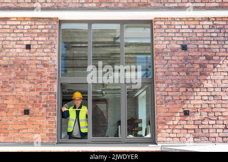 male builder with ruler measuring window Stock Photo