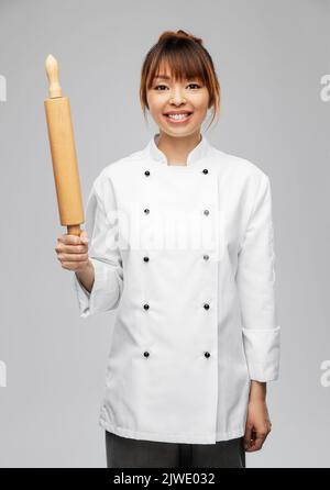 smiling female chef or baker with rolling pin Stock Photo