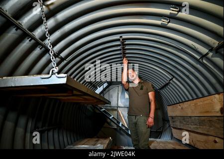 ZAPORIZHZHIA REGION, UKRAINE - SEPTEMBER 02, 2022 - A serviceman shows one of the special metal 'capsules' used for making improvements to the defensive installations, Zaporizhzhia, south-eastern Ukraine. Stock Photo