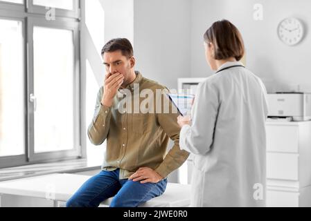 female doctor and coughing man at hospital Stock Photo